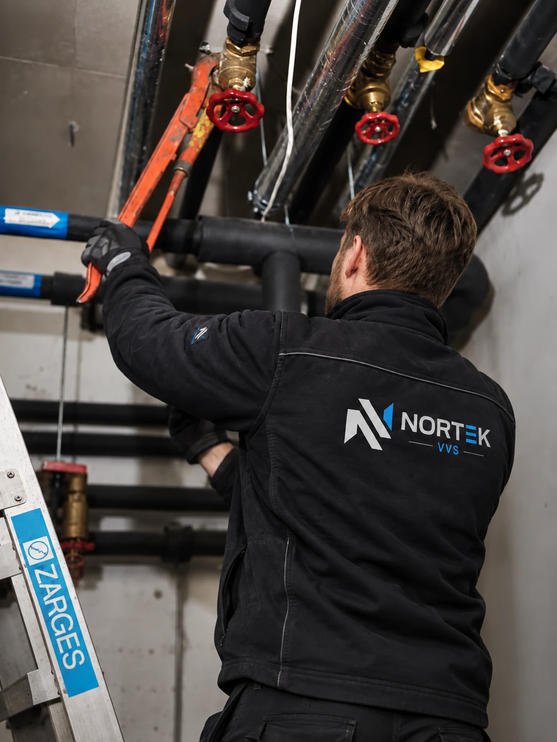 Nortek-rørlegger arbeider på et teknisk rørsystem